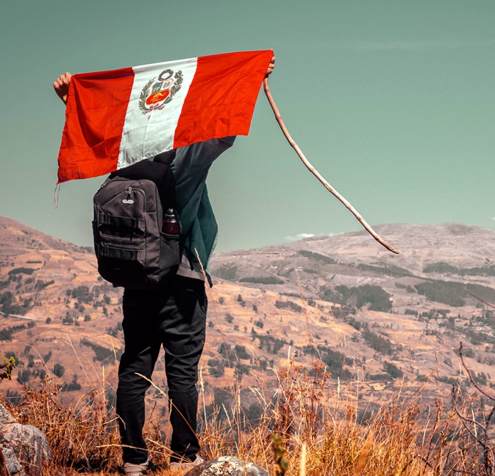 Student on a mountain with a Peruvian flag