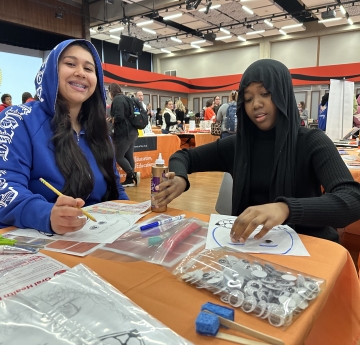 Two people completing a service project craft