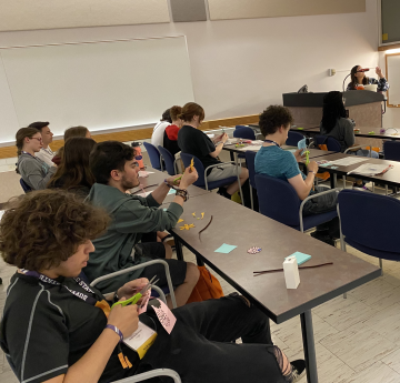 photo of students sitting at tables working on an art project.