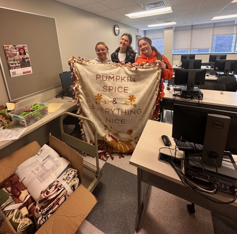 Buffalo State Volleyball players holding a DIY blanket they made.