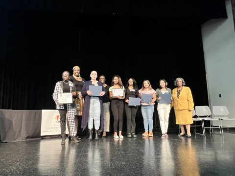 A group of people standing on stage with awards