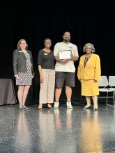 A group of people standing on stage with awards