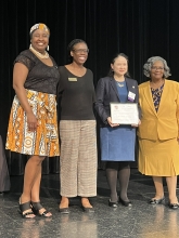 A group of people standing on stage with awards