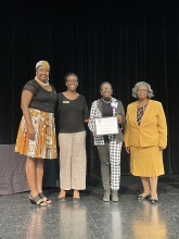 A group of people standing on stage with awards