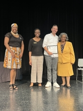 A group of people standing on stage with awards