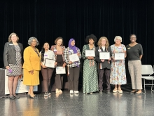 A group of people standing on stage with awards