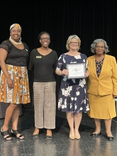 A group of people standing on stage with awards