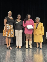 A group of people standing on stage with awards