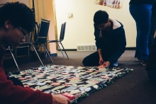 Making a no-sew blanket on the ground on campus.