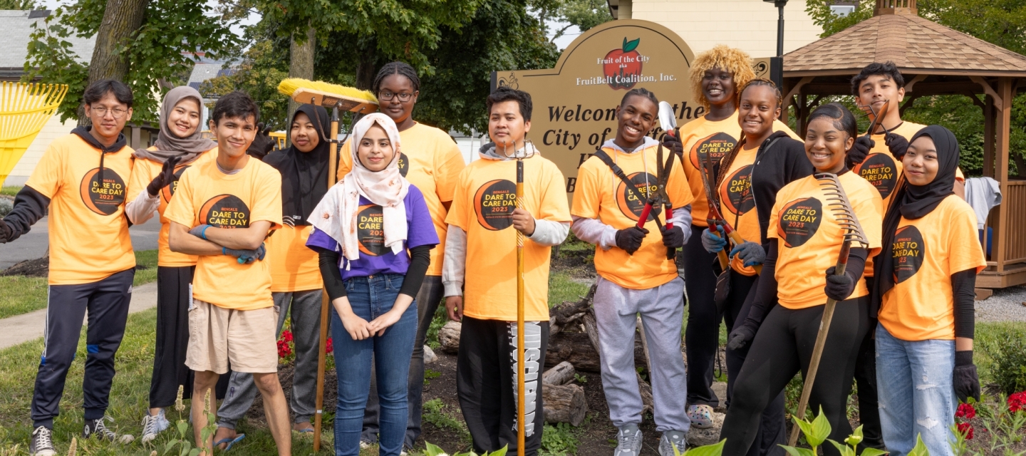 Photo of students posing with gardening tools.