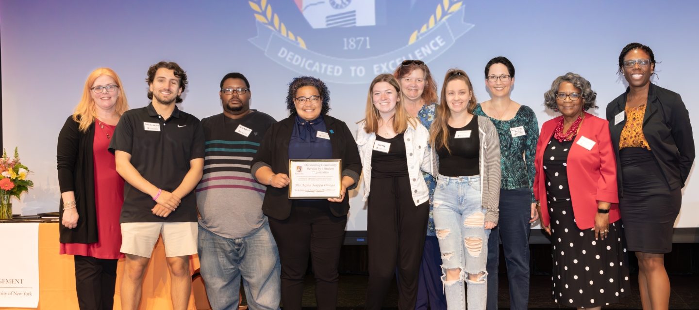 A group of people standing on stage with awards